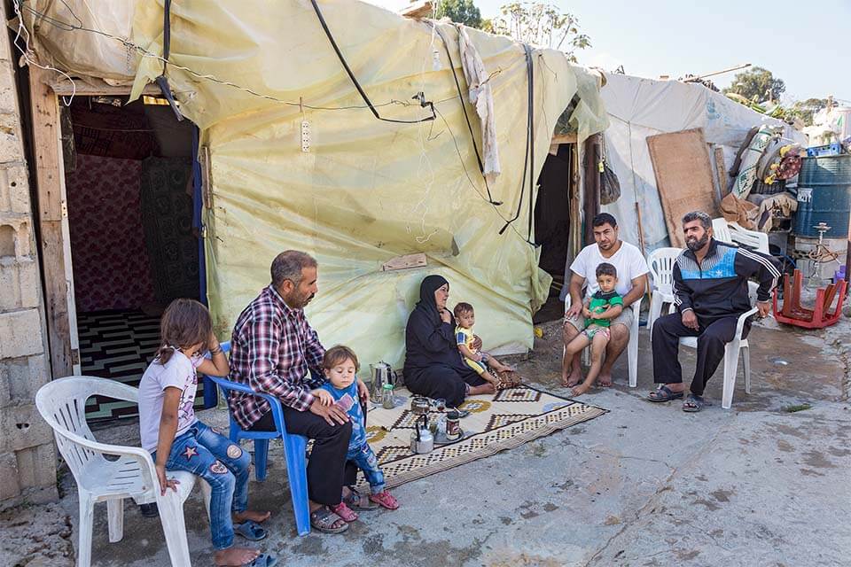 Familie vor ihrem Zelt im „Settlement“ für syrische Bürgerkriegsfamilien am Stadtrand von Sidon. Hier leben circa 120 Familien unter schwierigsten Bedingungen.