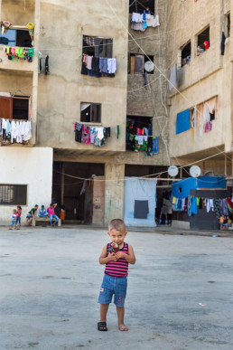 Kind spielt im Innenhof des „Settlement“ Hochhaus in Sidon.