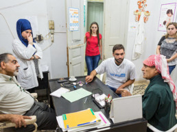 Untersuchungszimmer: (links, Dr. Dr. Ali Jouni (Healthstation), Krankenschwester und Mitarbeiterinnen der Healthstation, Addullah Nimje (Mitte, Cap Anamur Krankenpfleger) im Gespräch mit einem Patienten (syrischer Bürgerkriegs-Flüchtling) in der Healthstation in Sidon.