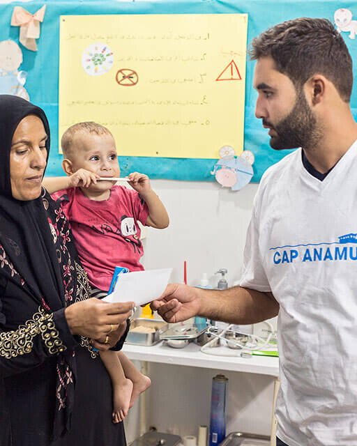 Addullah Nimje (Cap Anamur nurse) in a conversation with a patient (Syrian civil war refugee) at the health station in Sidon.