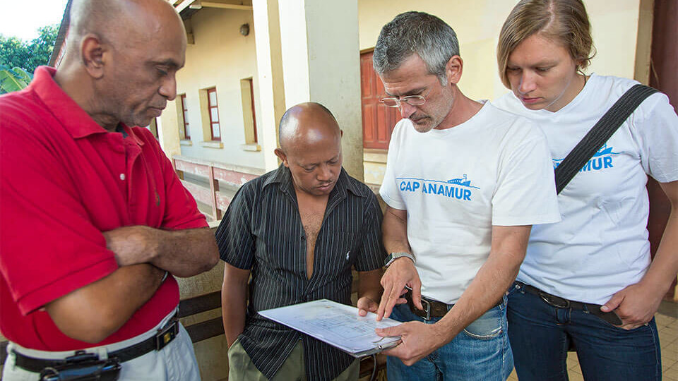 Andreas Tsukalas (2nd from right, organizer, architect and technician) on a tour of the Bezaha Reference Hospital (Centre Hositalier de Reference) with the head of surgery Dr. Mohamadi (left), the operations manager Mr. Gerard (center), the nurse Silke Schopf (right) Here with the reconstruction plan of the surgery, which Cap Anamur will completely renovate.