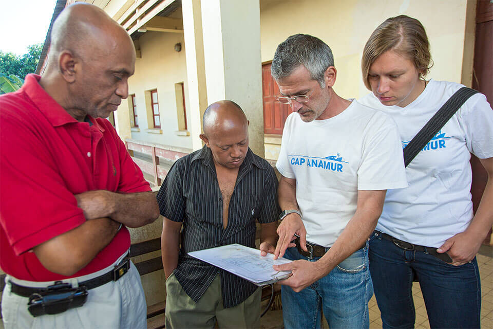 Andreas Tsukalas (2nd from right, organizer, architect and technician) on a tour of the Bezaha Reference Hospital (Centre Hositalier de Reference) with the head of surgery Dr. Mohamadi (left), the operations manager Mr. Gerard (center), the nurse Silke Schopf (right) Here with the reconstruction plan of the surgery, which Cap Anamur will completely renovate.