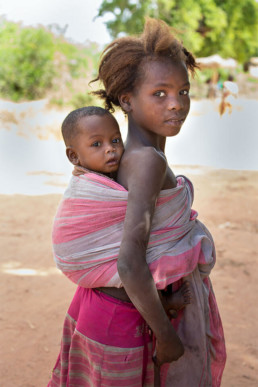 The big brothers and sisters lovingly take care of their siblings. Bezaha, Madagaskar.