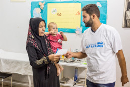 Lebanon: Addullah Nimje (Cap Anamur nurse) talking to a patient (Syrian civil war refugee) at the health station in Sidon.