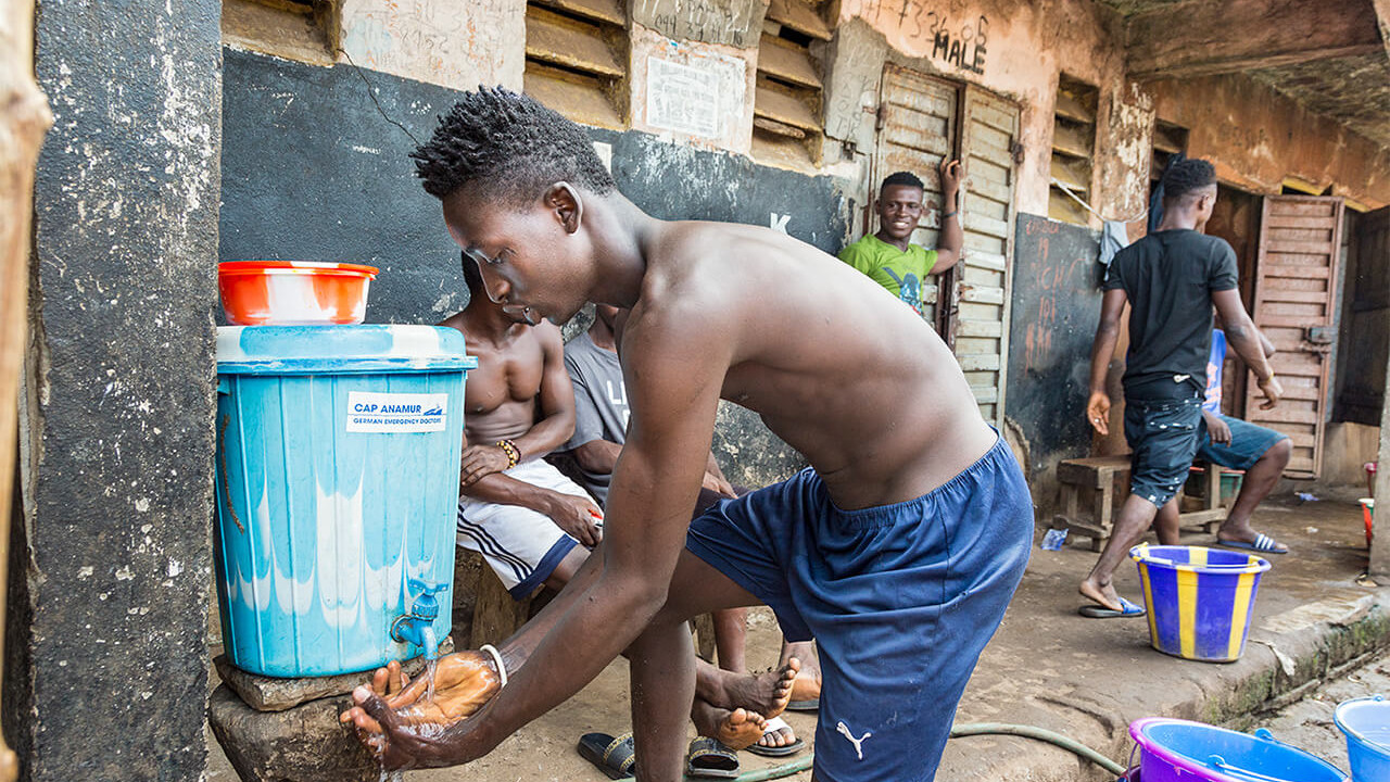 Washing container with soap in front of one of the 10 toilet houses.