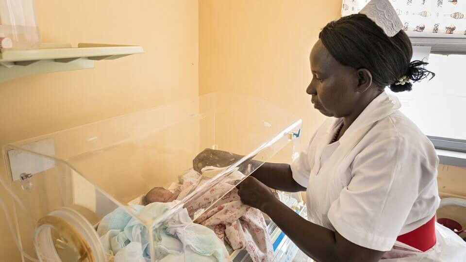 Eine Hebamme betreut Drillinge im Brutkasten im Hospital Kiryandongo, in dem Cap Anamur die medizinische Versorgung von Neugeborenen und Kindern verbessert hat.